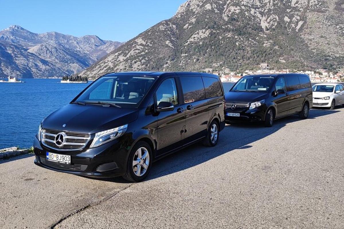 to varebiler parkert på en vei nær et vannområde