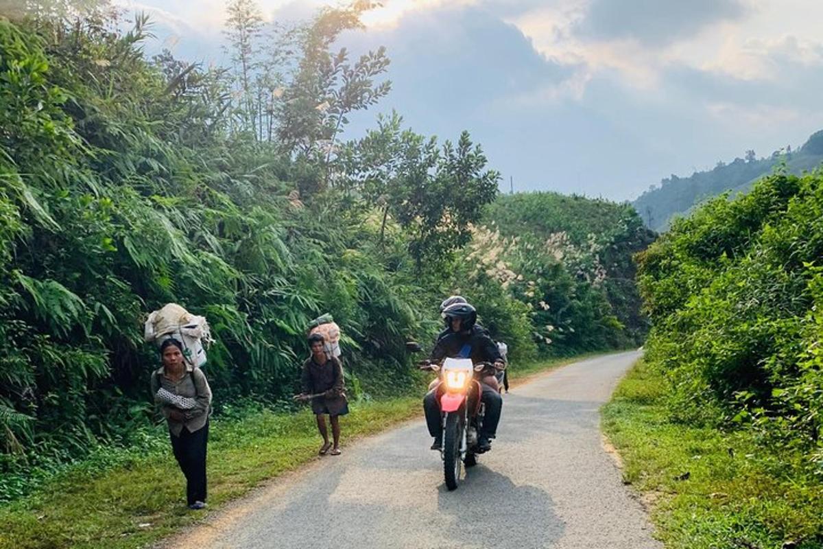 un uomo in motocicletta che percorre una strada con due donne