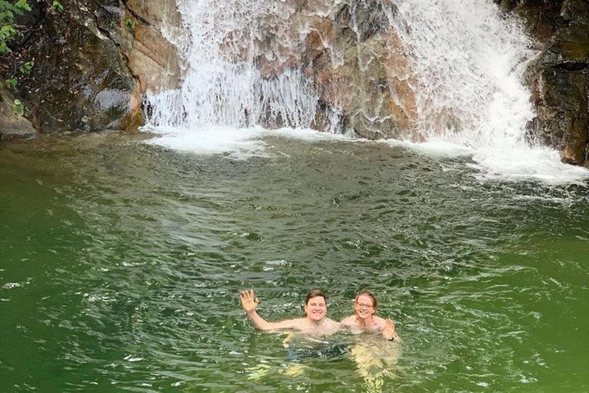 un uomo e una donna che nuotano in una cascata