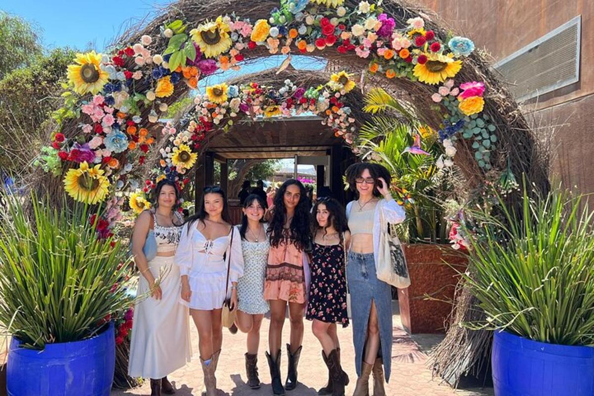 a group of women standing in front of a floral arch