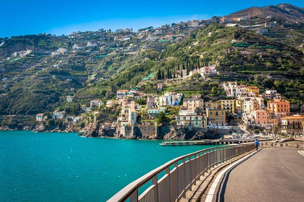 un ponte sopra uno specchio d'acqua con case su una collina