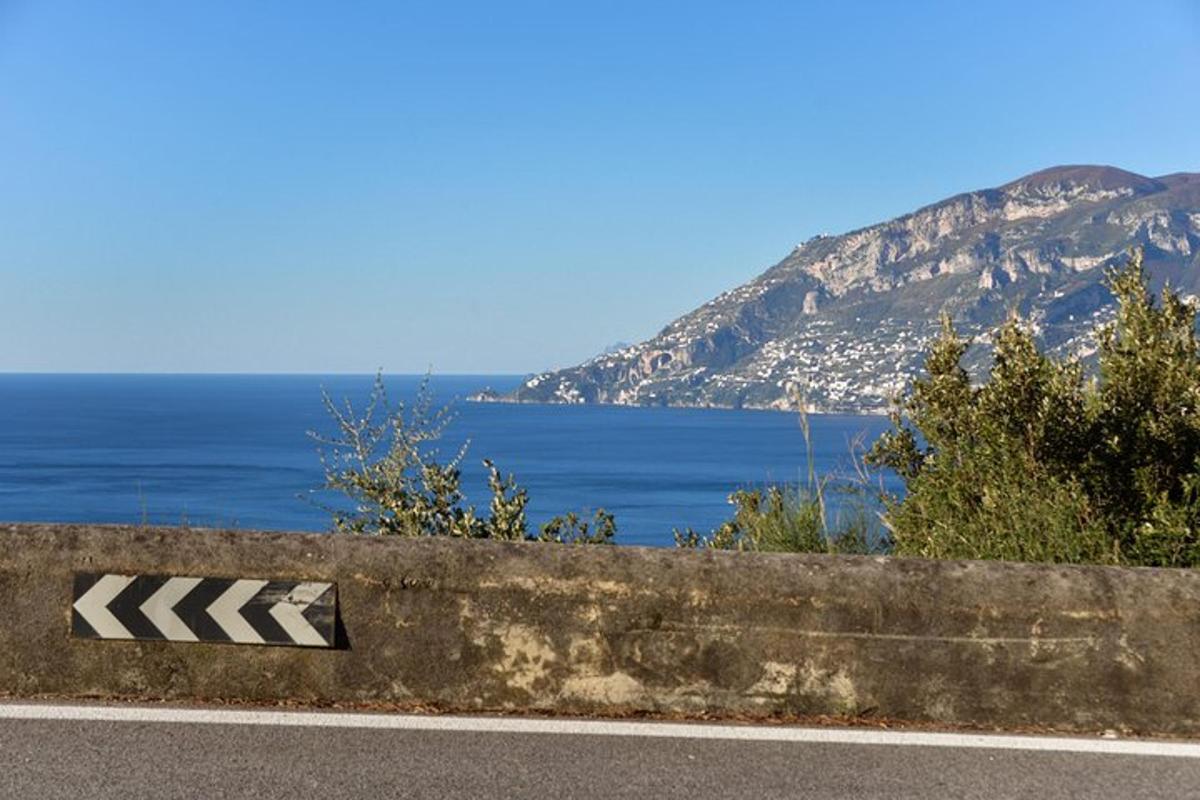 un cartello sul ciglio di una strada vicino all'oceano
