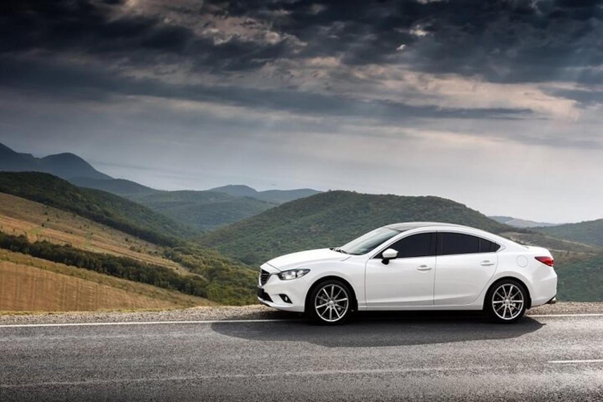 Un coche blanco aparcado al costado de una carretera