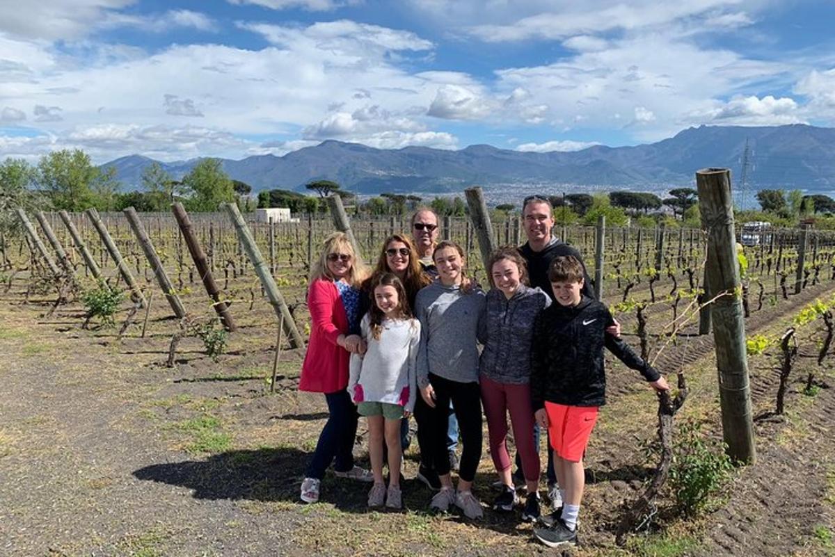 Una familia posando para una foto en un viñedo.