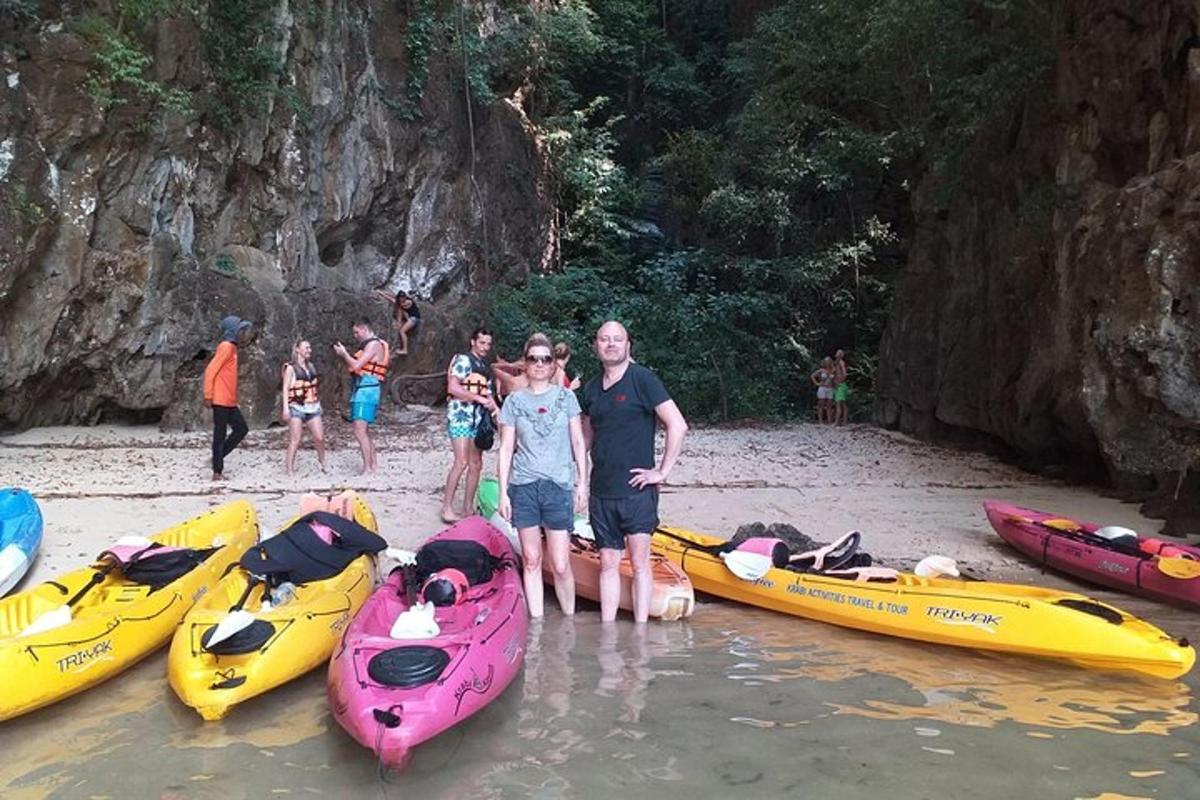 un gruppo di persone in piedi accanto ai kayak su una spiaggia