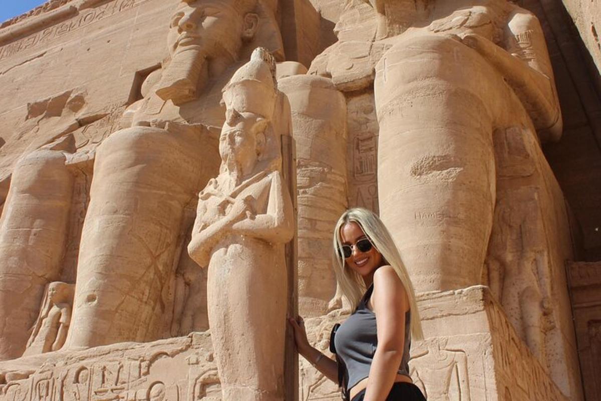uma mulher está parada em frente a uma estátua