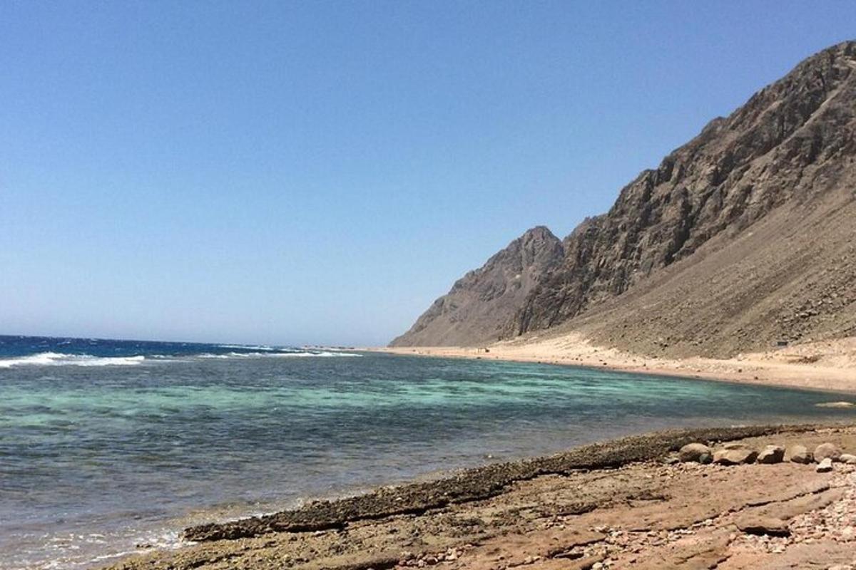 o plajă cu oceanul și munții în fundal