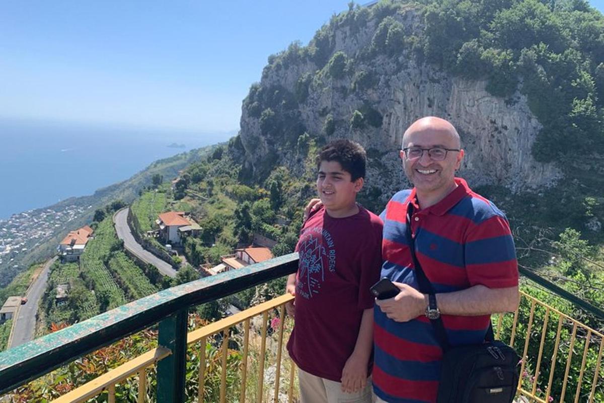 dois homens em pé em uma varanda com vista para uma montanha