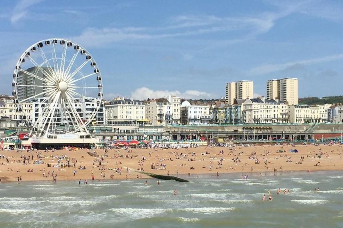 una platja amb una roda de fira i una multitud de gent