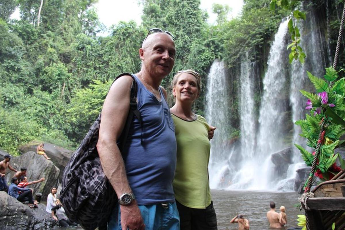 un uomo e una donna in piedi davanti a una cascata