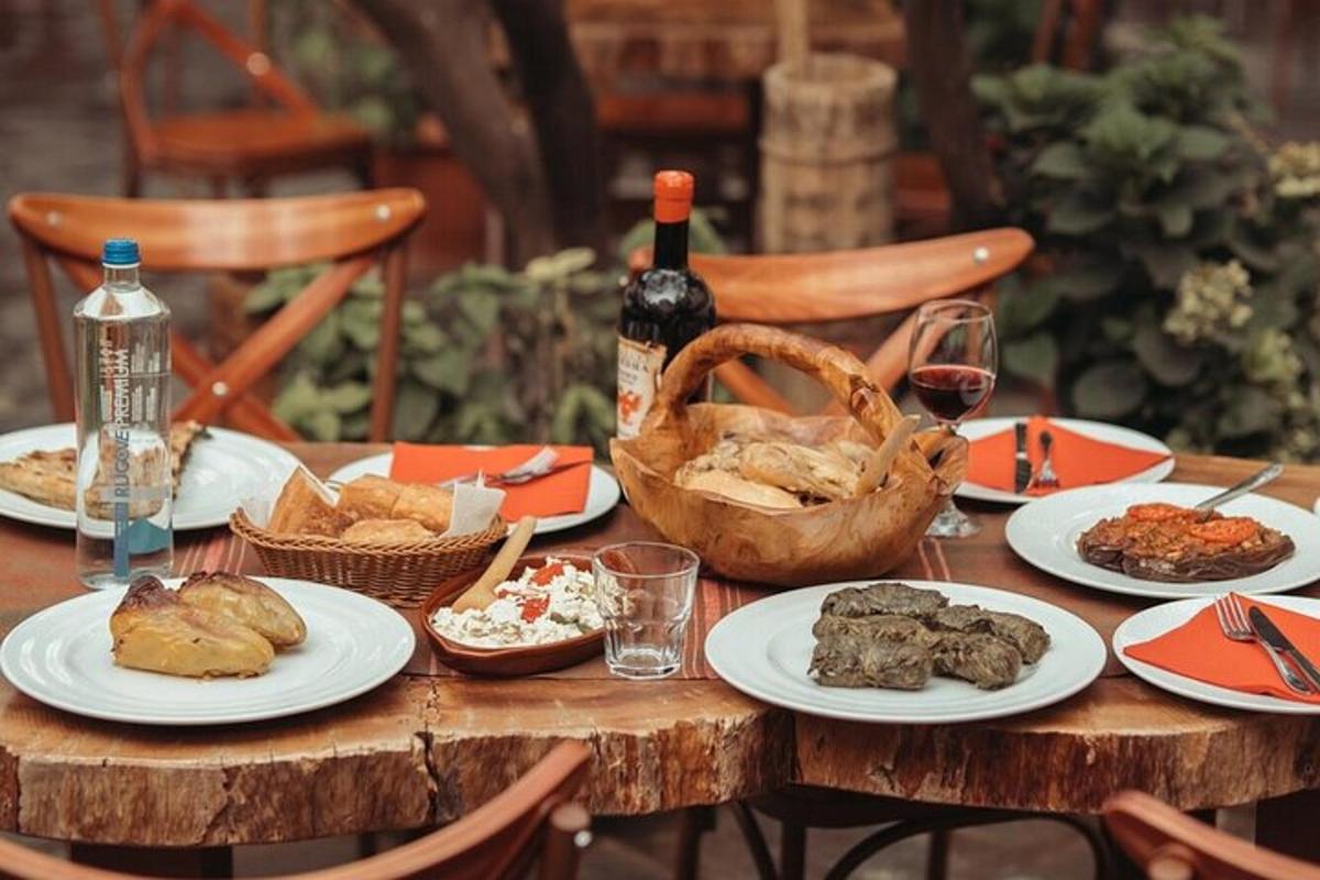 egy fából készült asztal tányérokkal, étellel és egy üveg borral