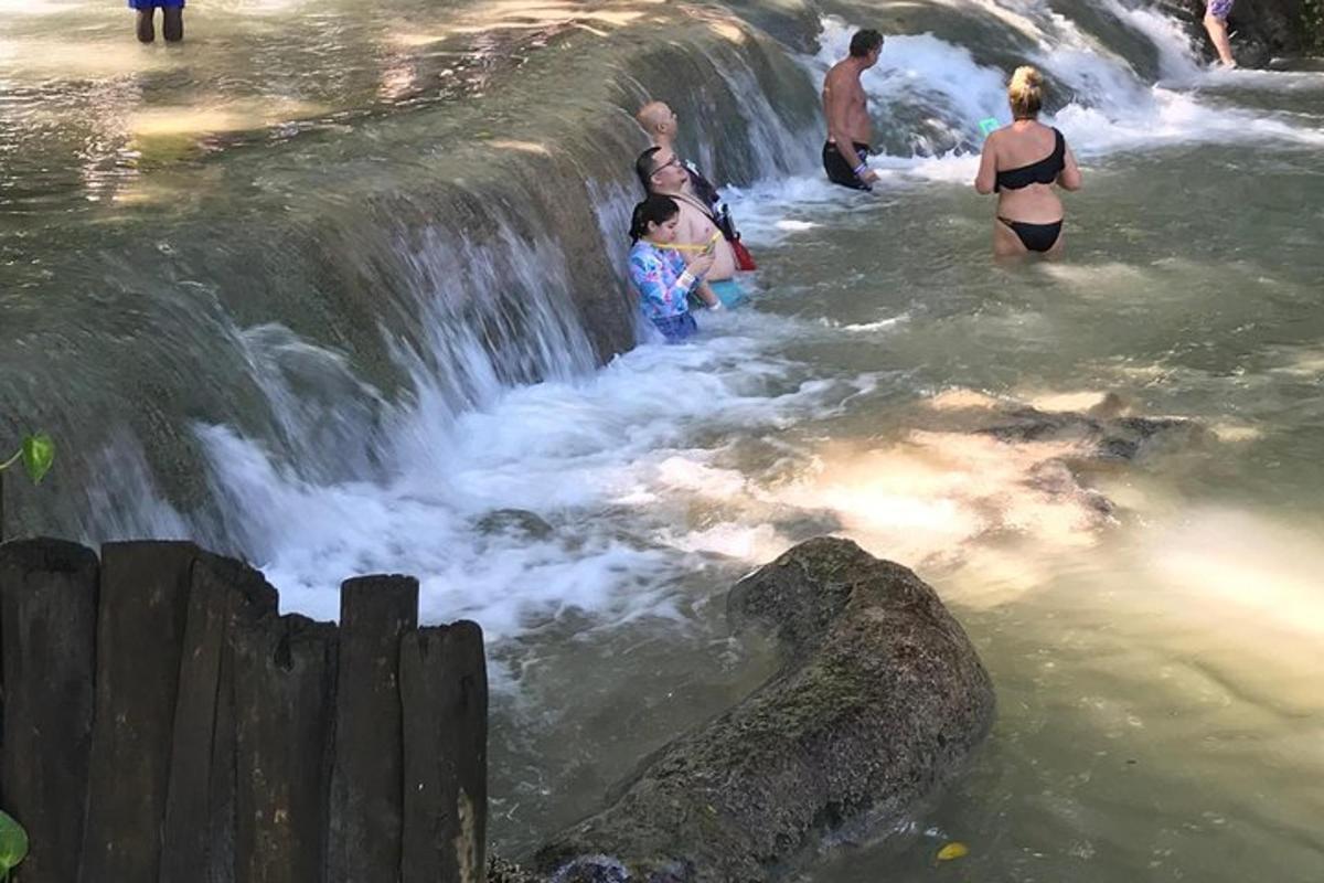 sekumpulan orang di dalam air di air terjun