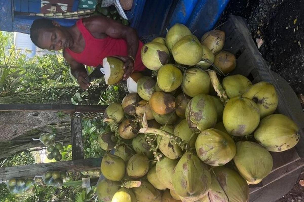 a man is standing next to a large pile of fruit