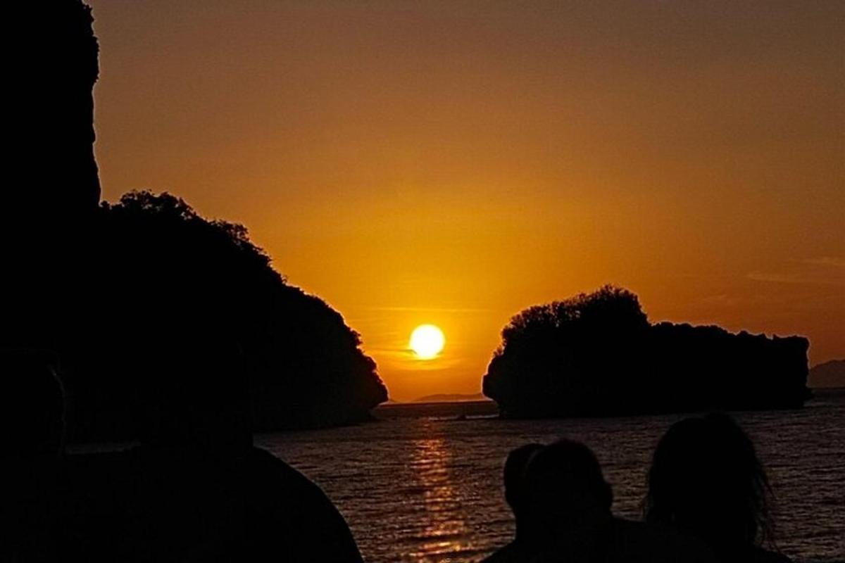 due persone che guardano il tramonto sull'acqua