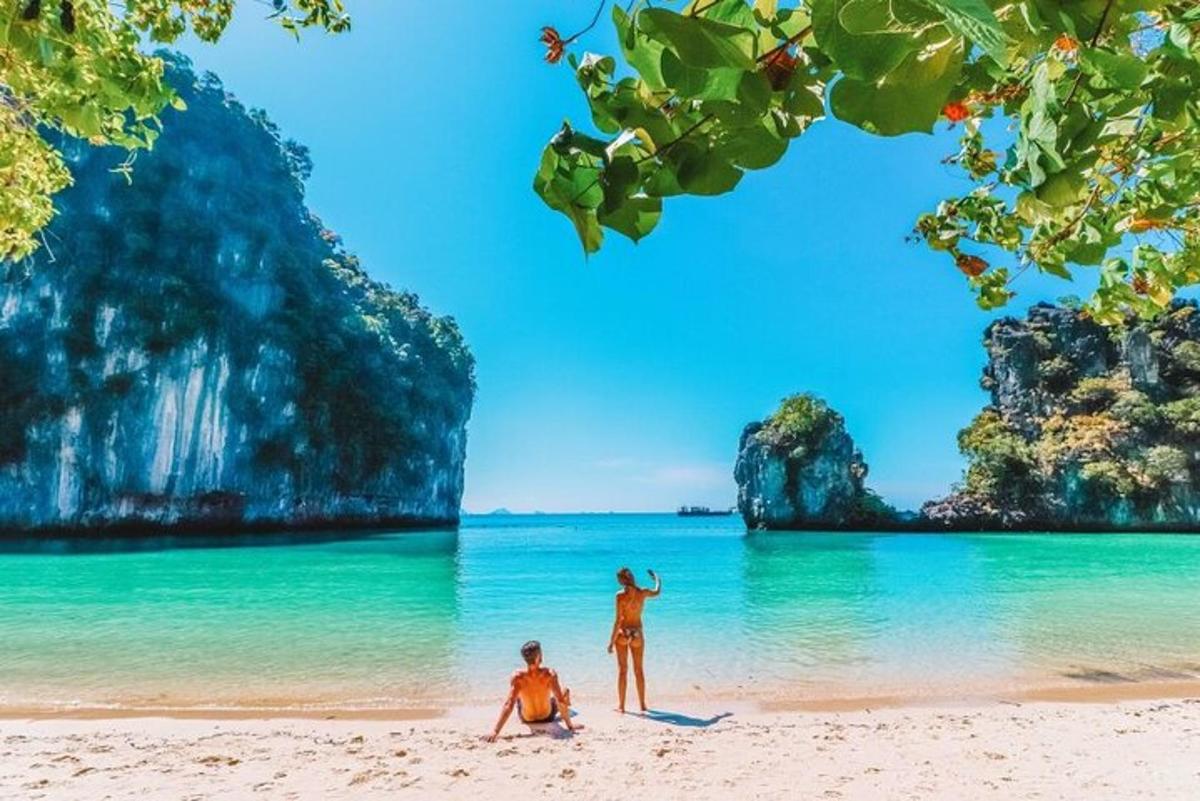 due persone in piedi su una spiaggia di fronte all'oceano