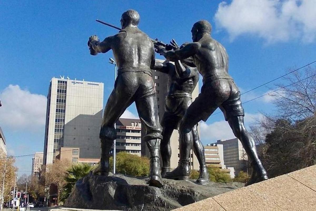 una statua di tre uomini con fucili in una città