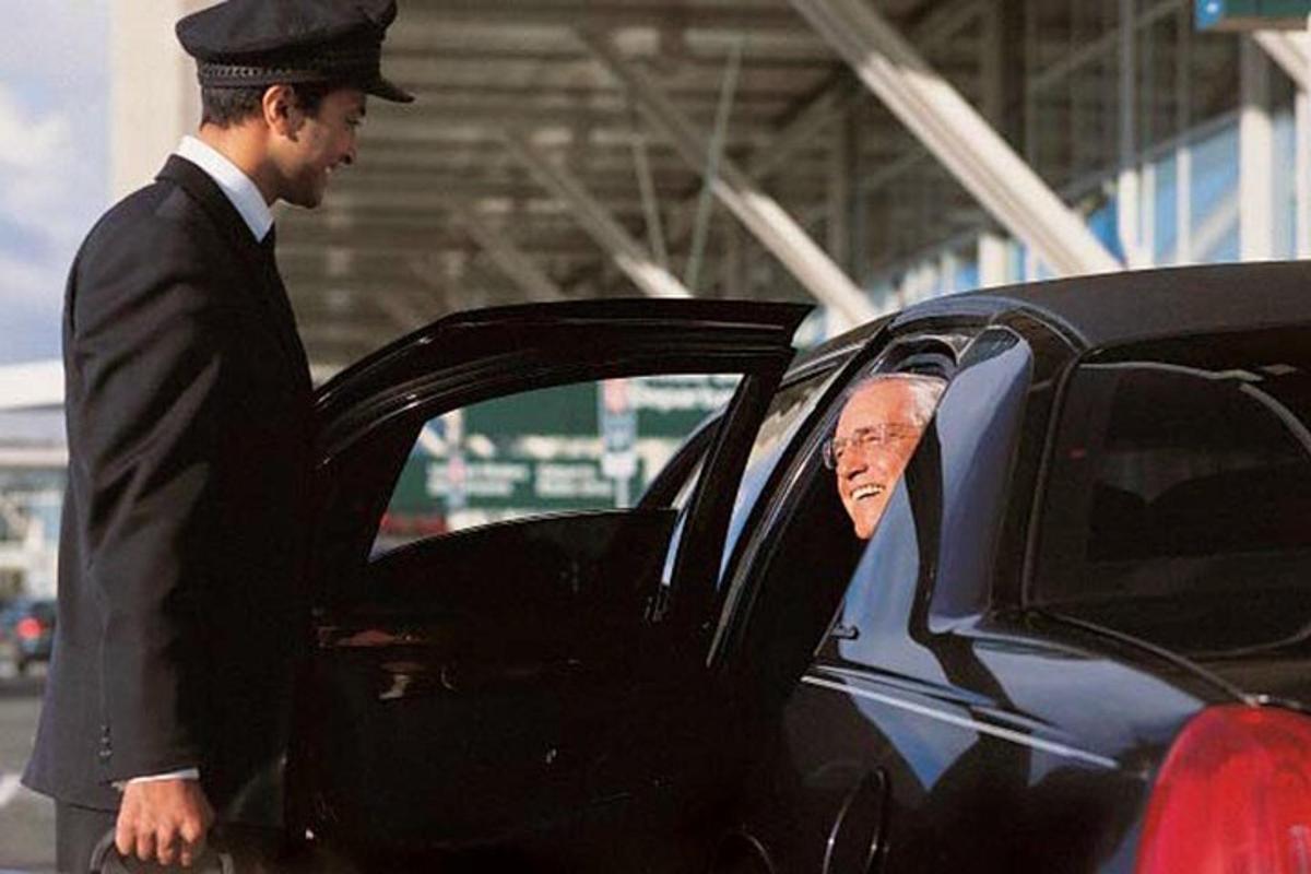 a man in a suit standing next to a car