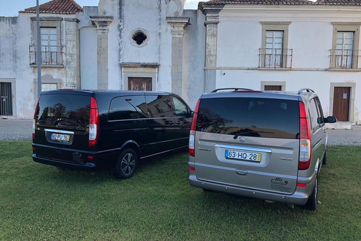 kaks hoone ees pargitud autot