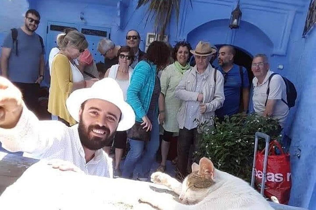 en gruppe mennesker, der står omkring en mand og en kat