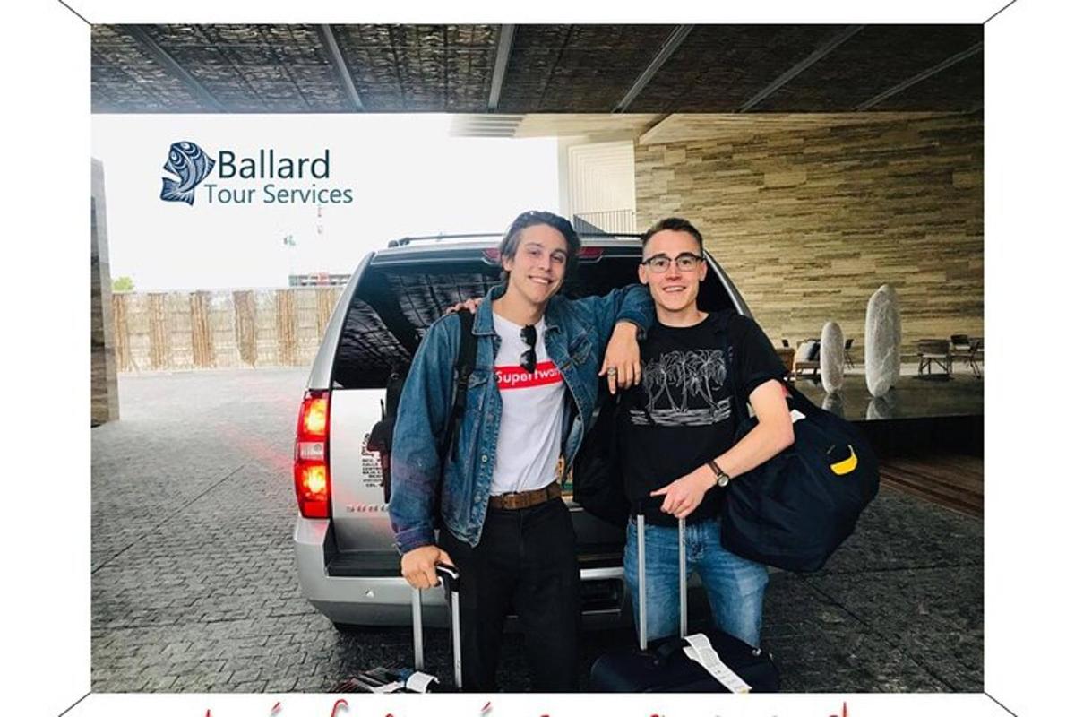 two men are standing in front of a car