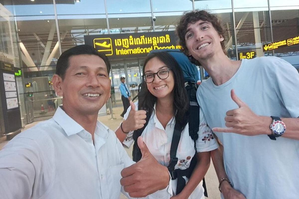 deux hommes et une femme levant le pouce dans un aéroport