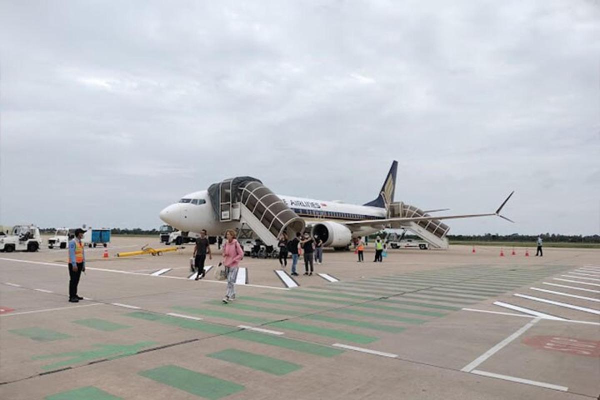 a group of people walking towards an airplane on the runway
