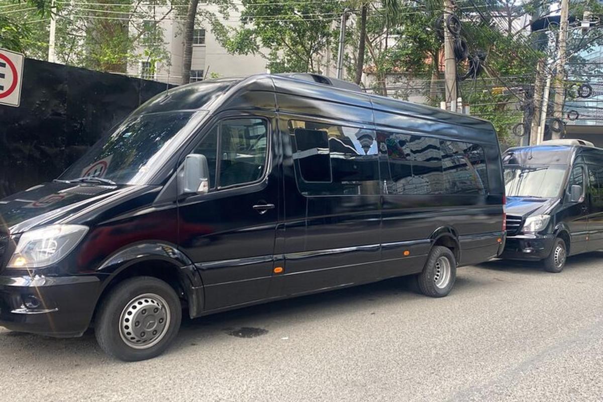 duas vans pretas estacionadas na beira de uma rua