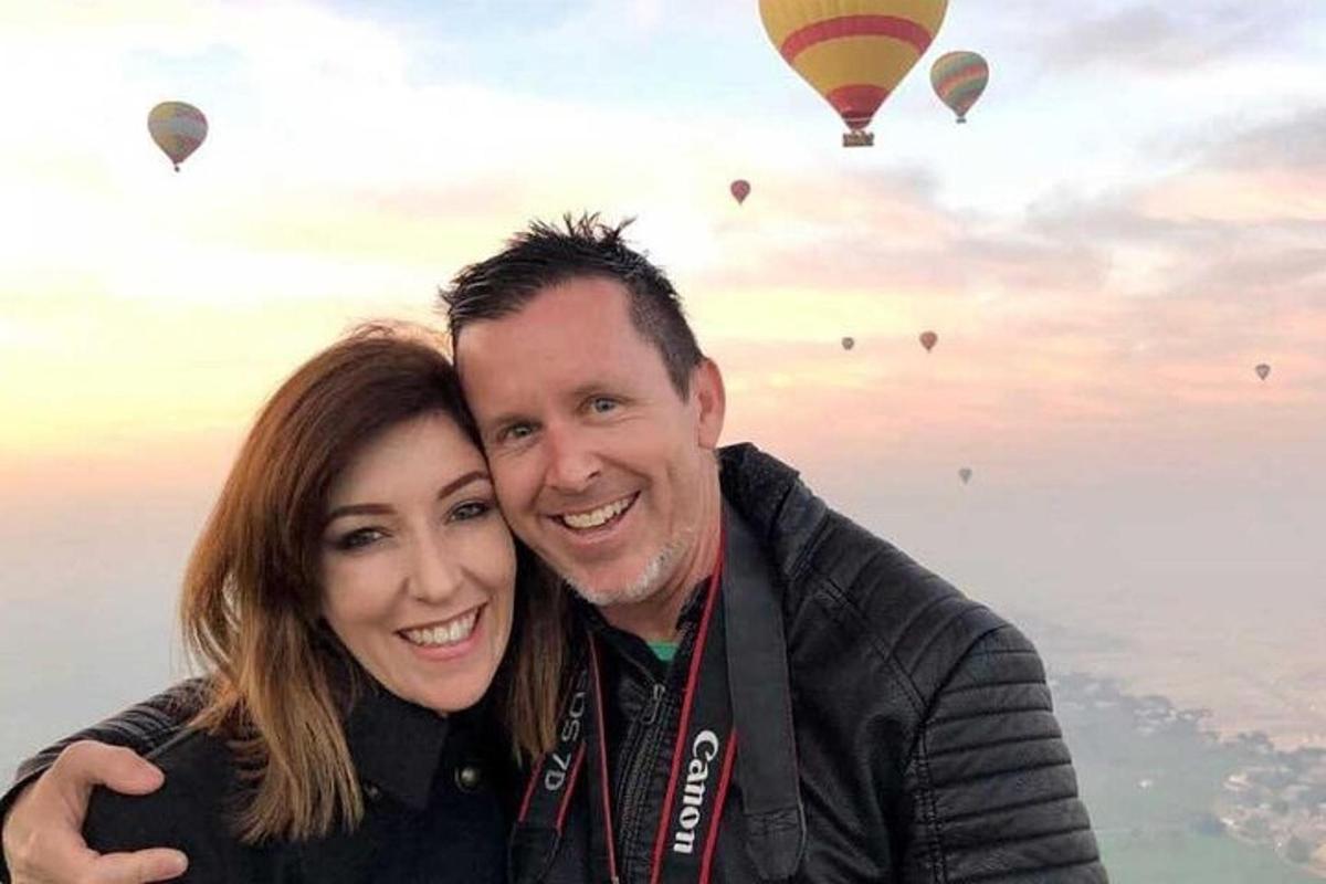 un uomo e una donna posano per una foto con mongolfiere