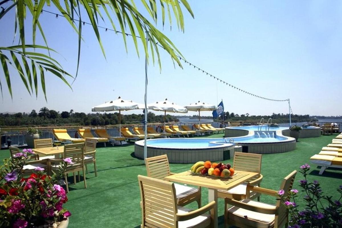 un resort con tavoli, sedie e una piscina