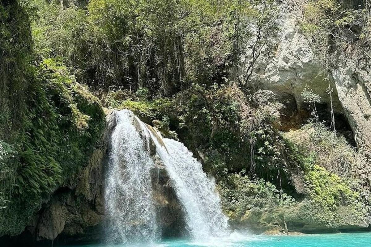 una cascata sul fianco di una montagna con acqua blu