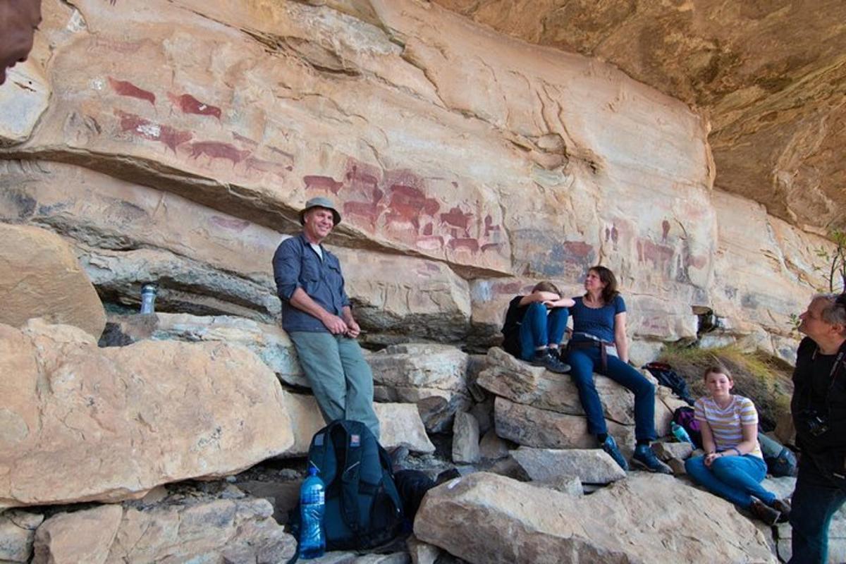 a group of people sitting on rocks in a cave
