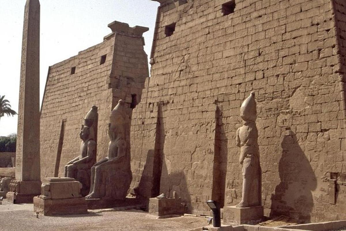 statuju grupa blakus ķieģeļu ēkai
