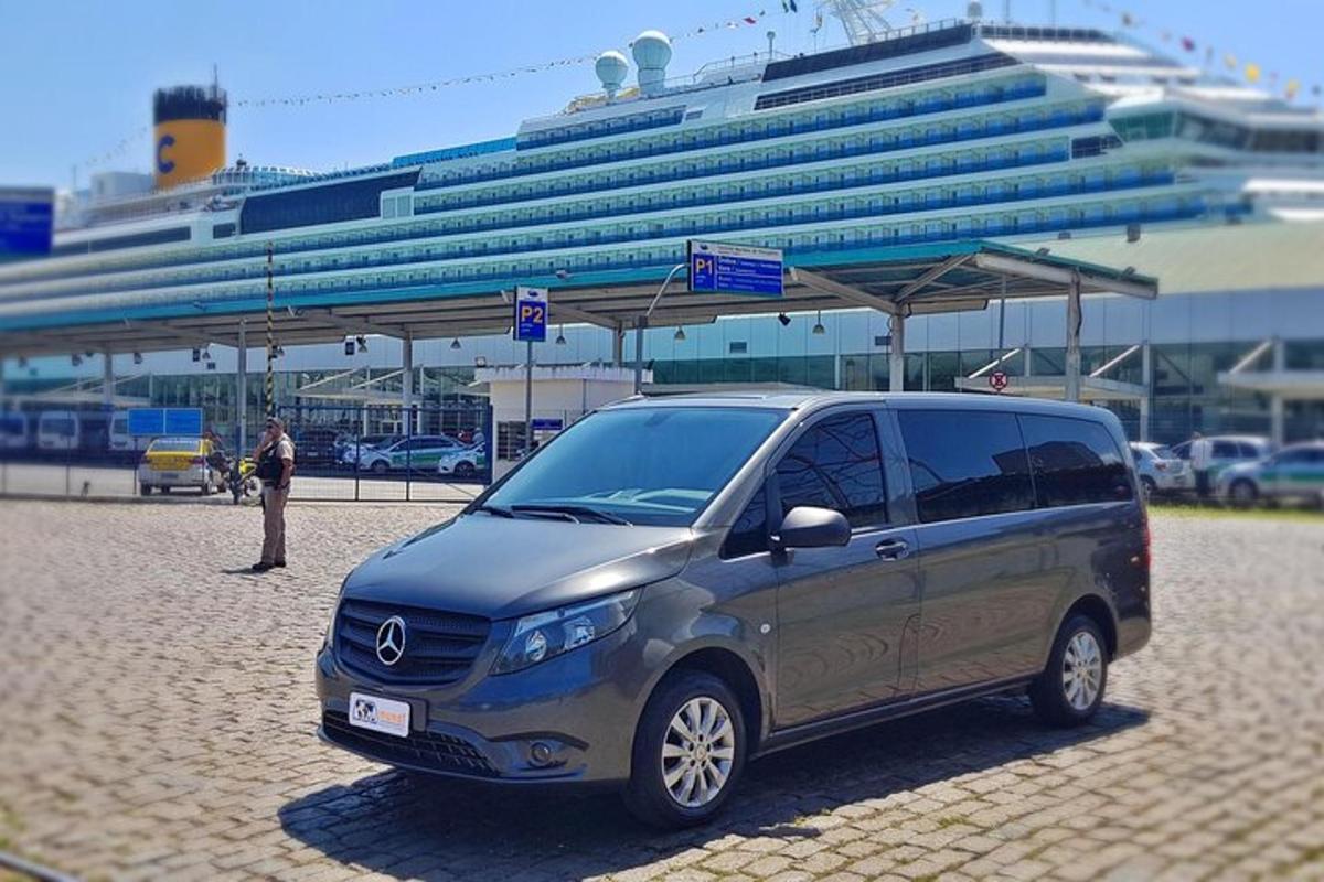 a small van parked in front of a cruise ship