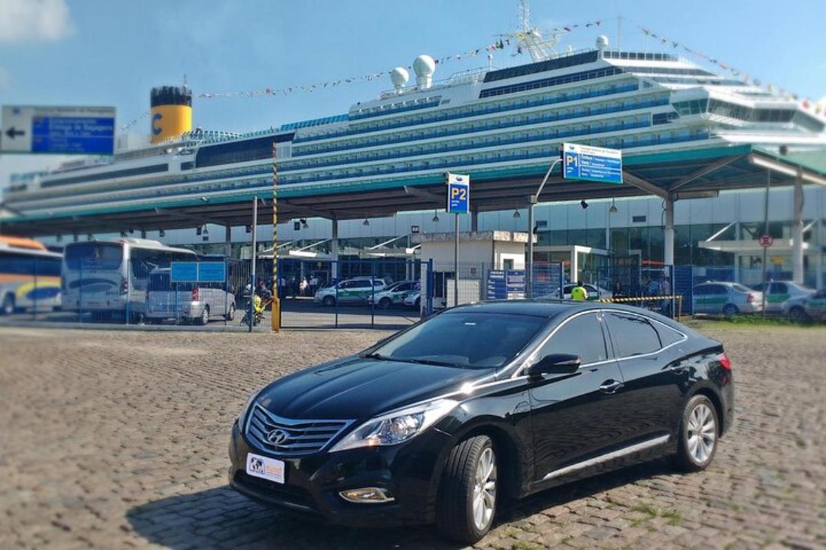 a black car parked in front of a cruise ship