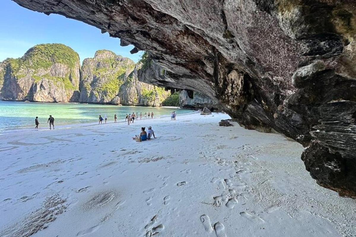 un gruppo di persone su una spiaggia vicino a una grotta