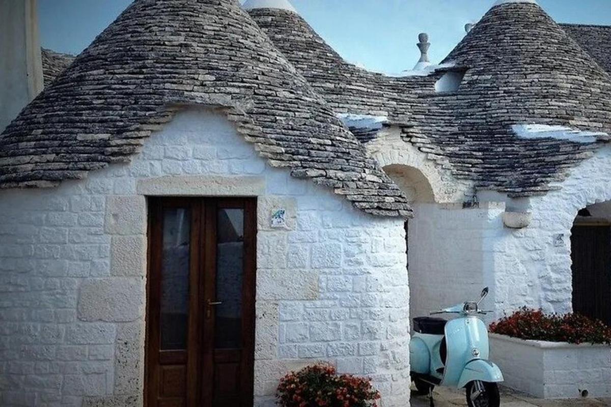 isang bahay na may bubong na may scooter na nakaparada sa labas