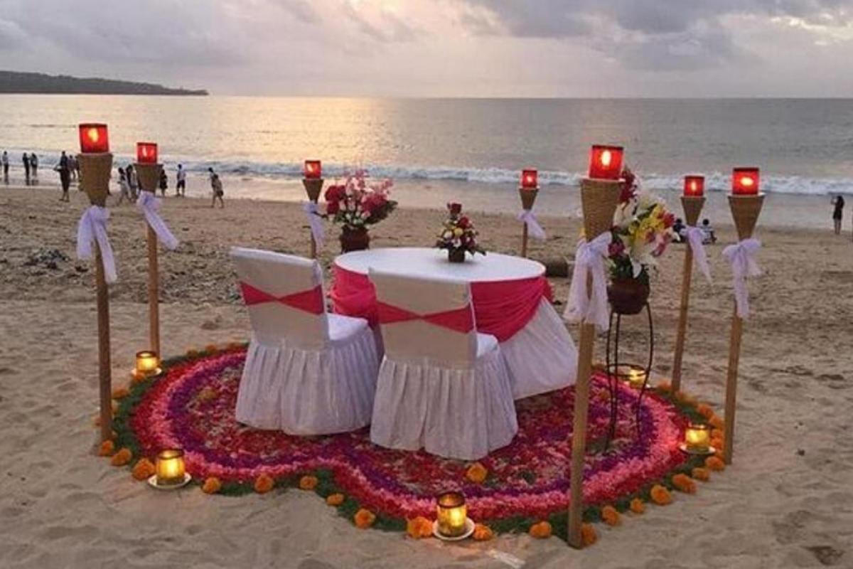 ein Tisch am Strand mit Kerzen und Blumen