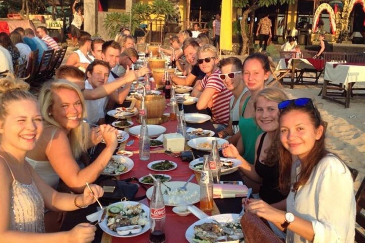um grupo de pessoas sentadas à mesa comendo comida
