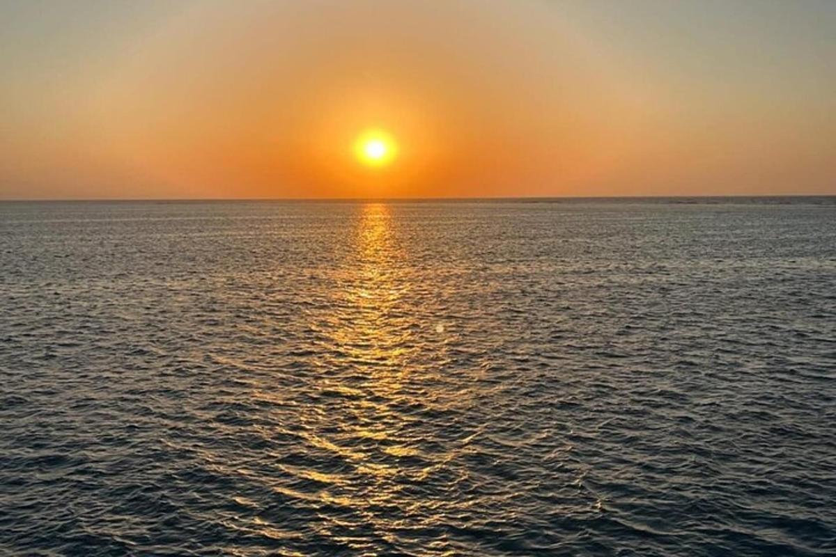 ένα ηλιοβασίλεμα πάνω από τον ωκεανό με τη δύση του ηλίου