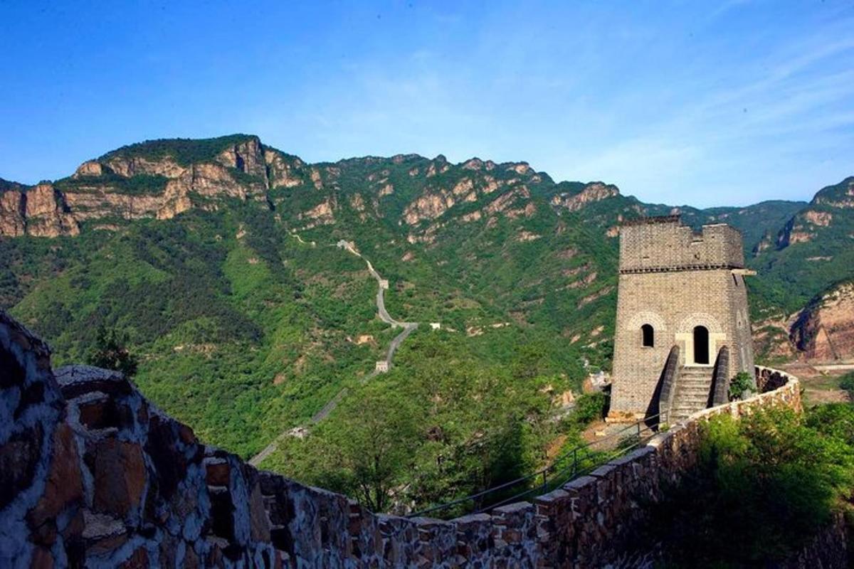 a building on a wall with mountains in the background