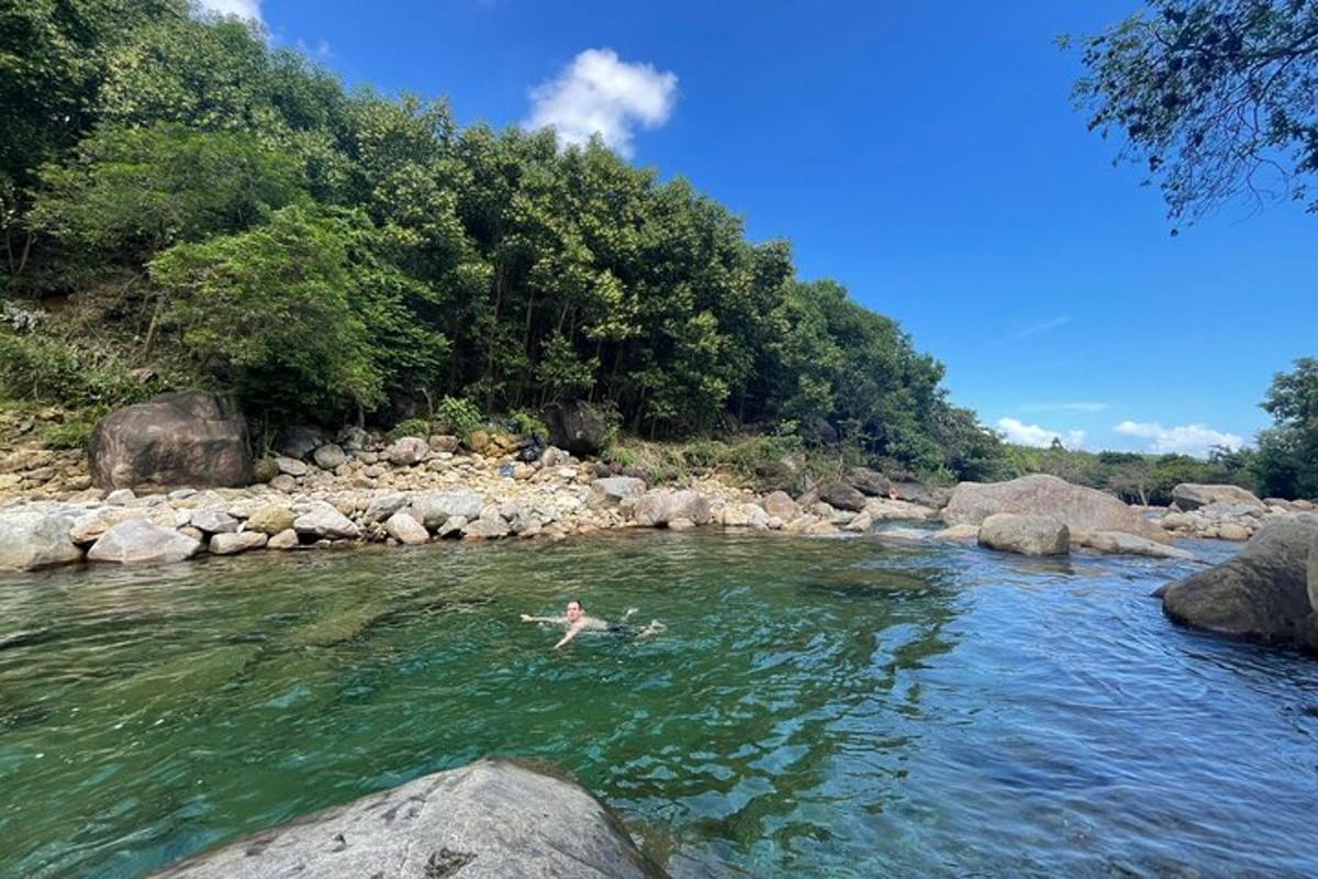 una persona che nuota in un fiume con delle rocce