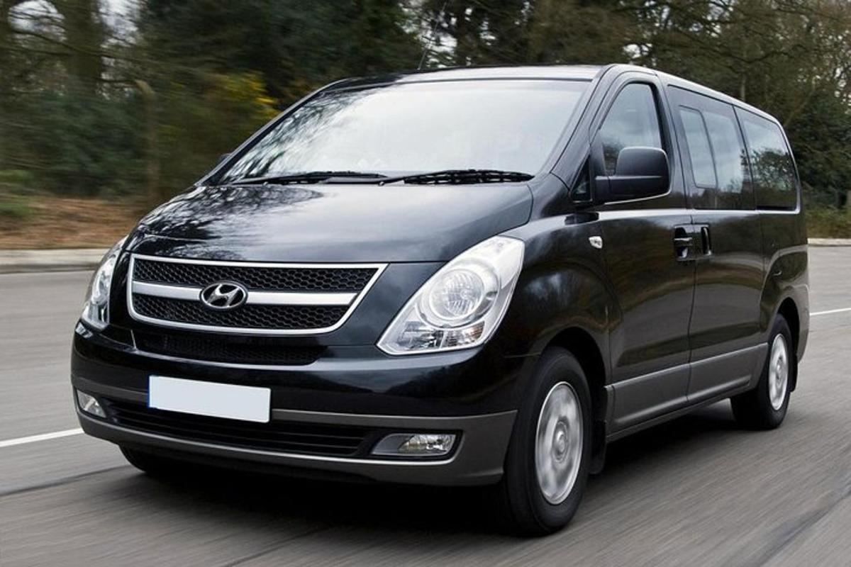 a black van is driving down a road