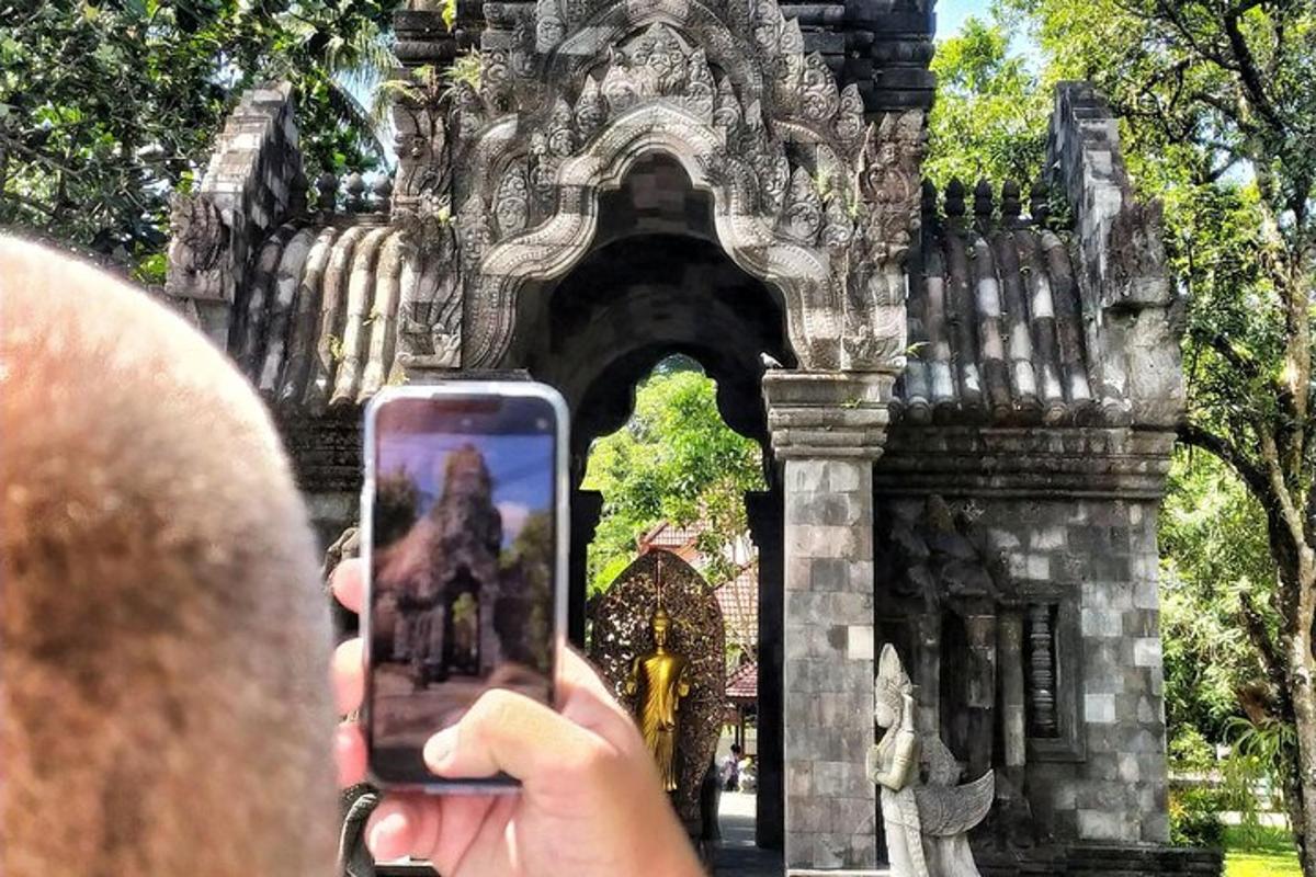 особа која фотографише зграду мобилним телефоном