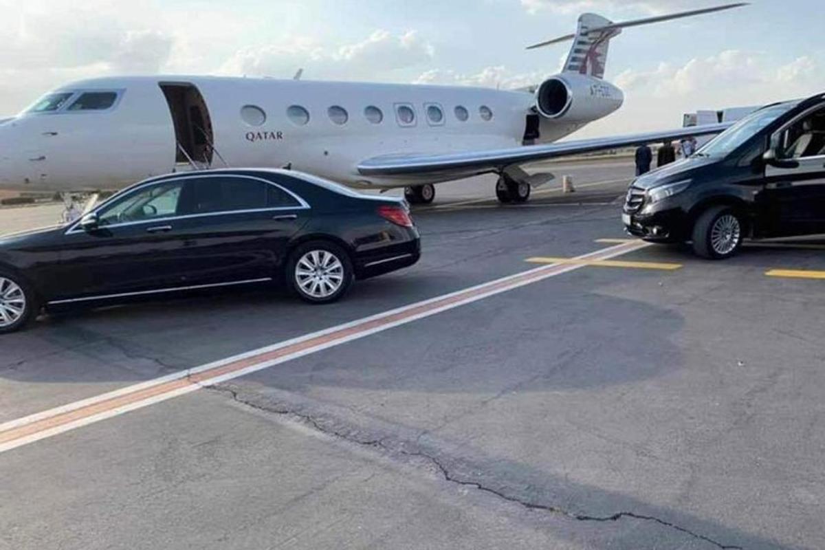 un'auto è parcheggiata accanto a un aereo