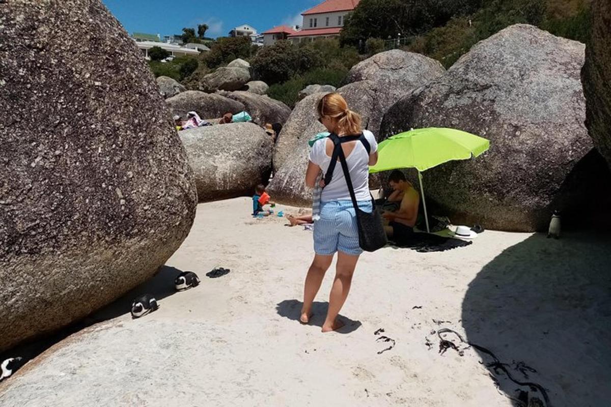 una mujer parada en la playa con una sombrilla