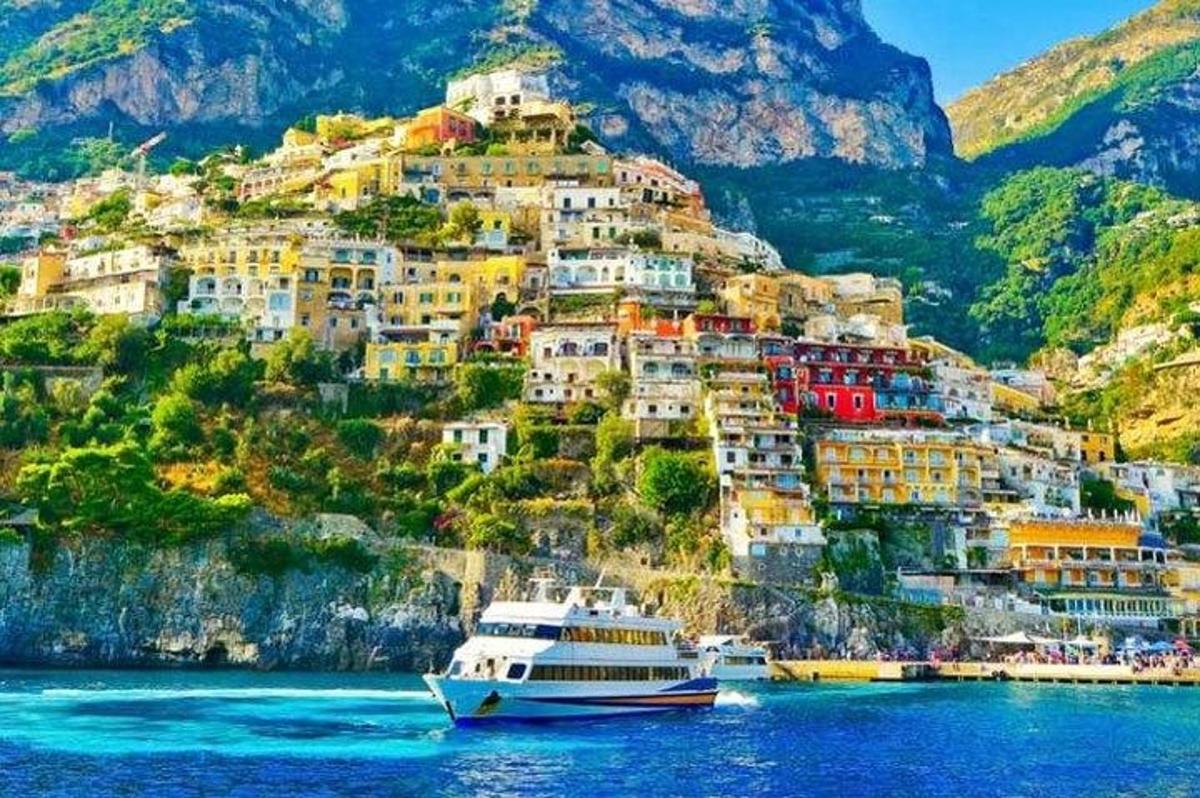 a boat in the water in front of a mountain