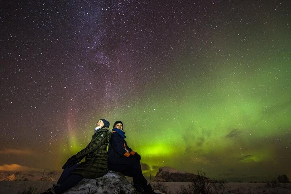 kaks inimest istuvad tähistaeva all kaljul