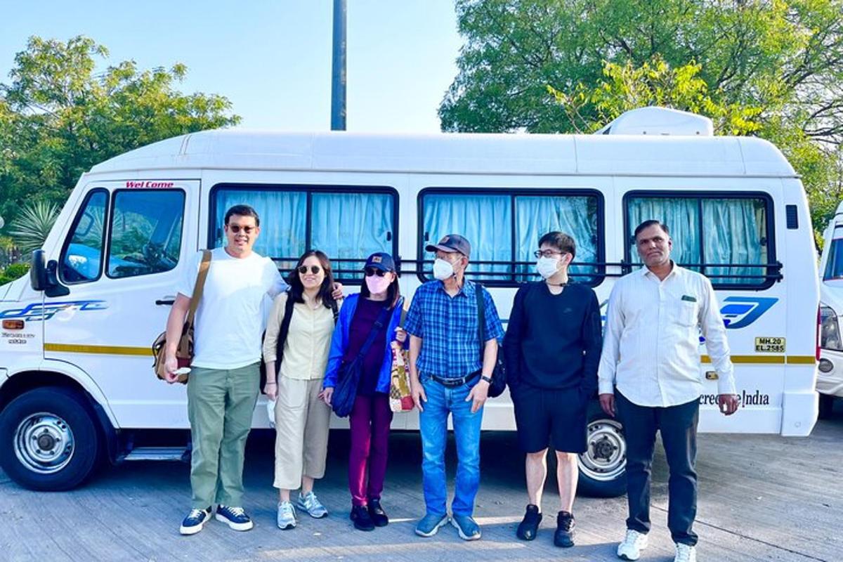a group of people standing in front of a bus