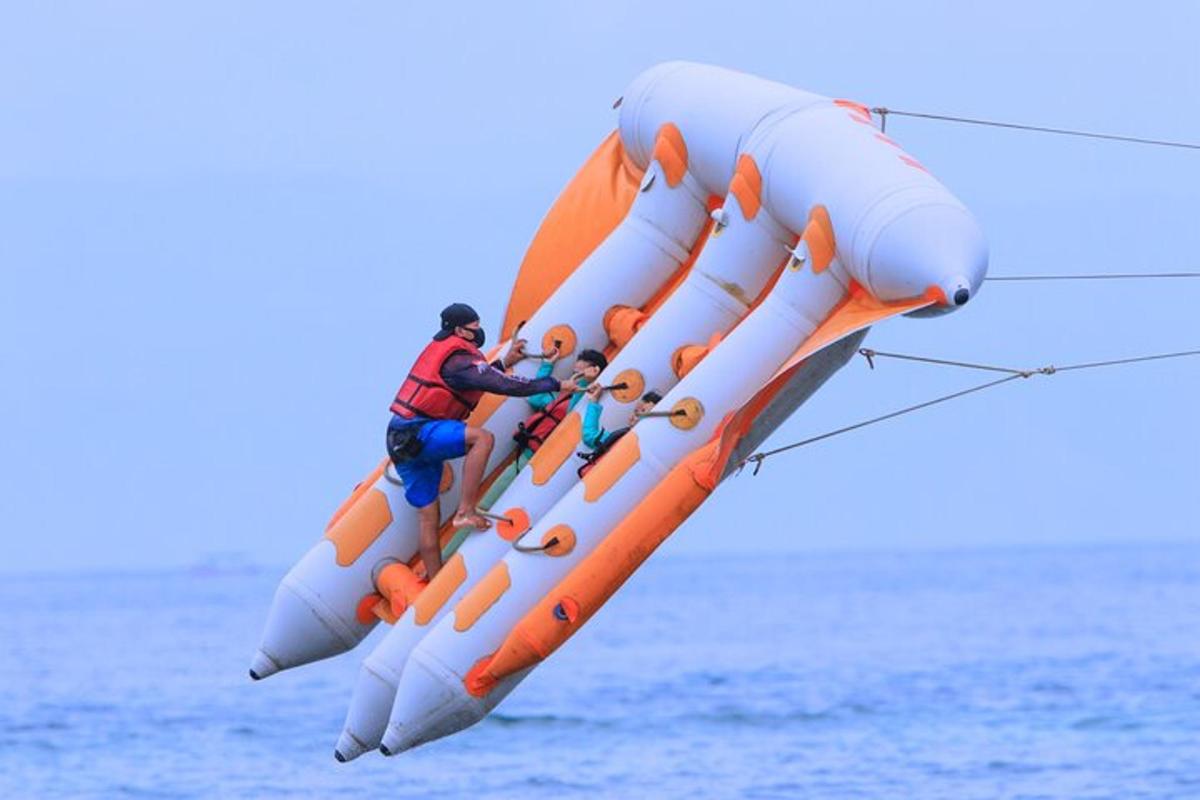 Un hombre y dos niños viajando en un inflable.