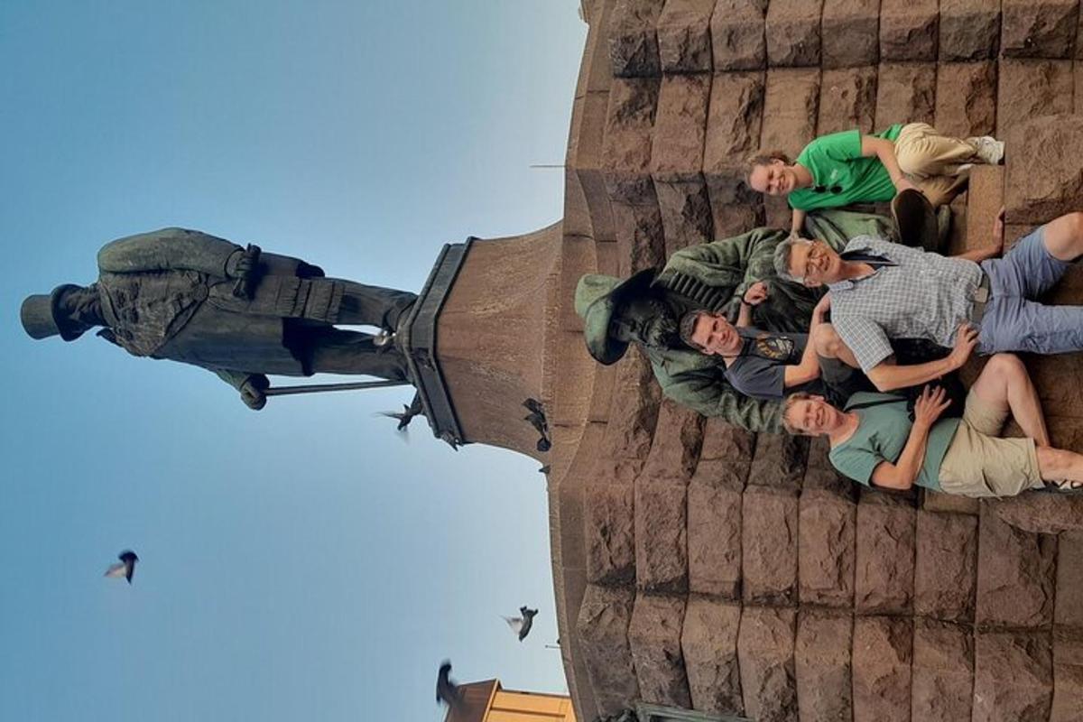 grupp inimesi, kes istuvad hoone küljel